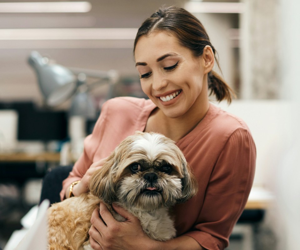 smiling woman holding small dog